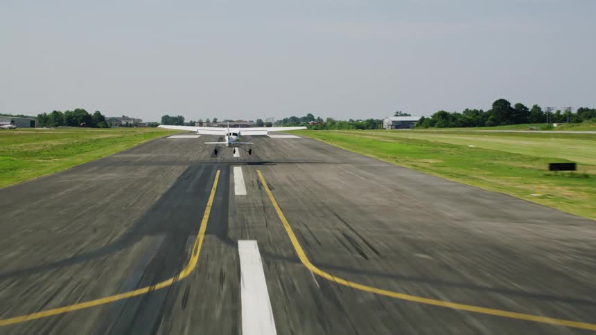 Small plane landing on a runway during the day