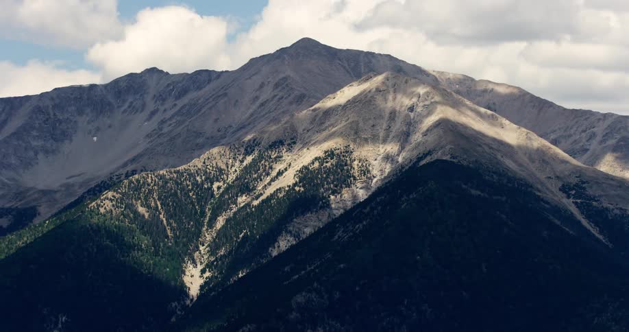 A time lapse shows clouds passing over a rocky mountain range