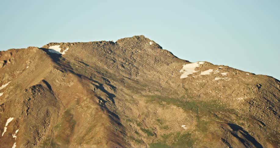 Cliff gave a mountain expanse on a cloudless blue sky day