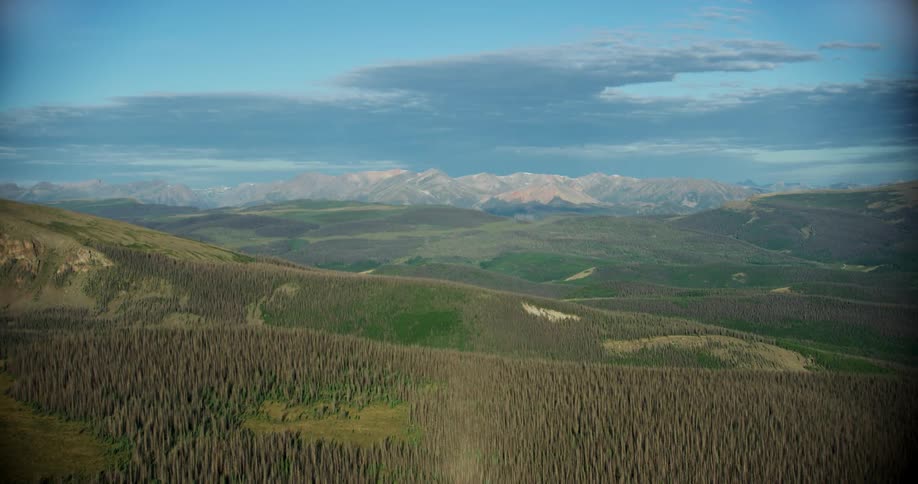 Aerial landscape of hills and mountains with forest vegetation and a blue sky with clouds