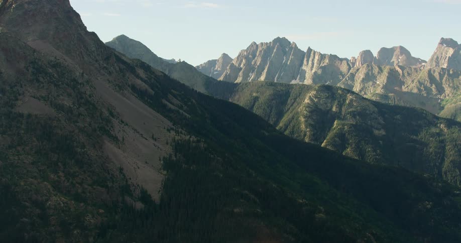 Aerial landscape of hills and mountains with peaks and cliffs and greenish forests