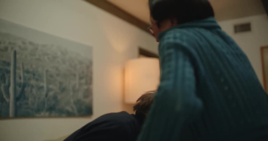 Wife helping her elderly husband to get up from the sofa and both of them smiling together