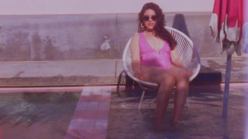 A woman sits in a chair and kicks water around with her feet