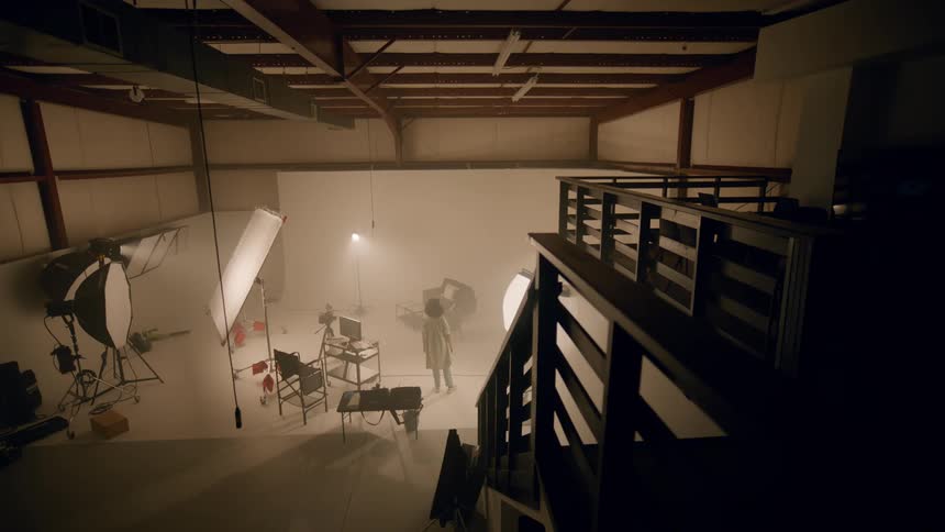 Woman entering and observing a recording studio with equipment and lighting