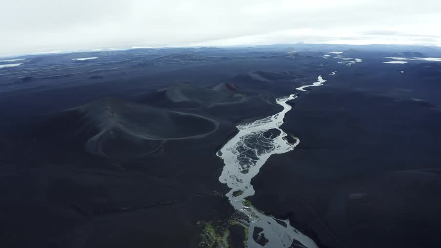 A stream of water is flowing through the mountainous landscape