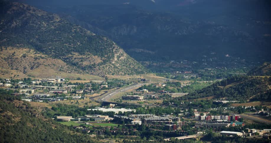 Aerial panorama and an urban city built in the middle of hills with mountains around