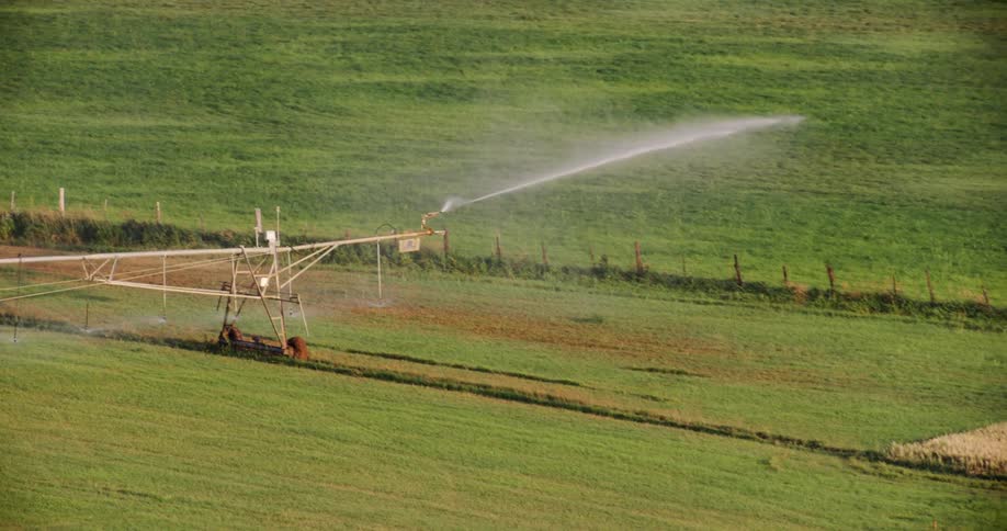 An irrigator sprays water on a field