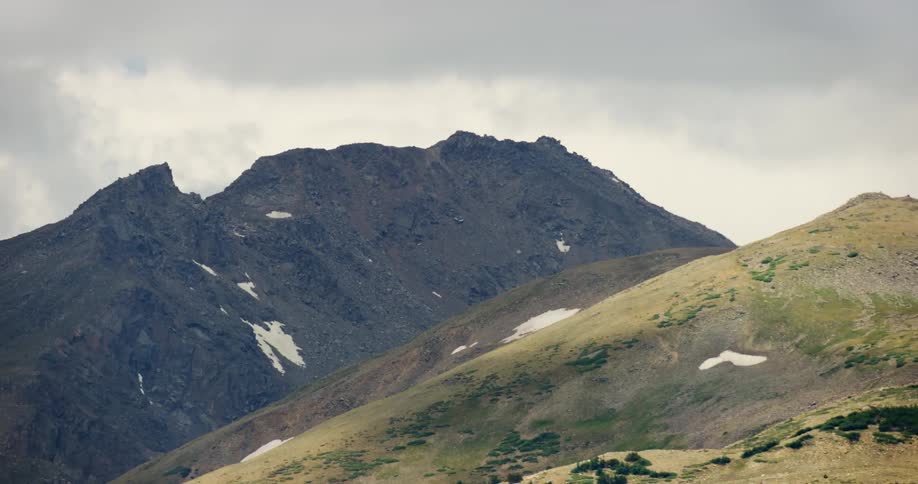 Aerial landscape of hills and mountains with flakes of snow on a cloudy day