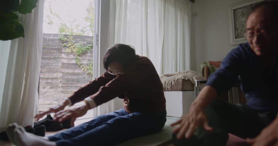 A man and woman do yoga together