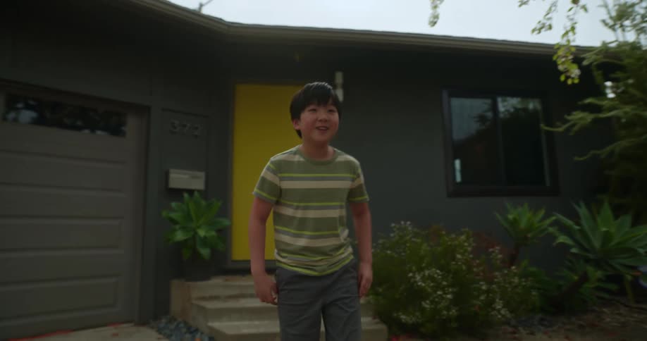 Smiling boy in the backyard watching his grandfather ride a scooter