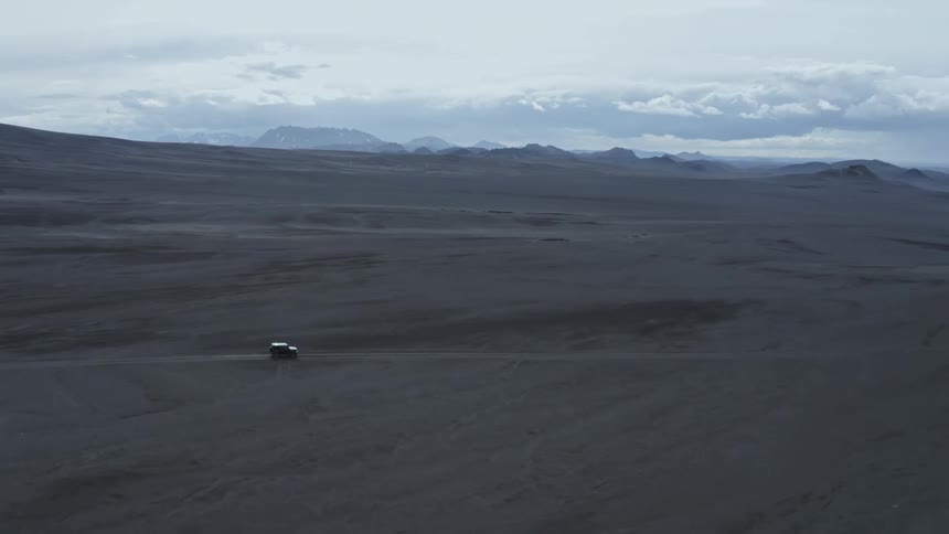 Car driving on an empty road in the middle of the desert