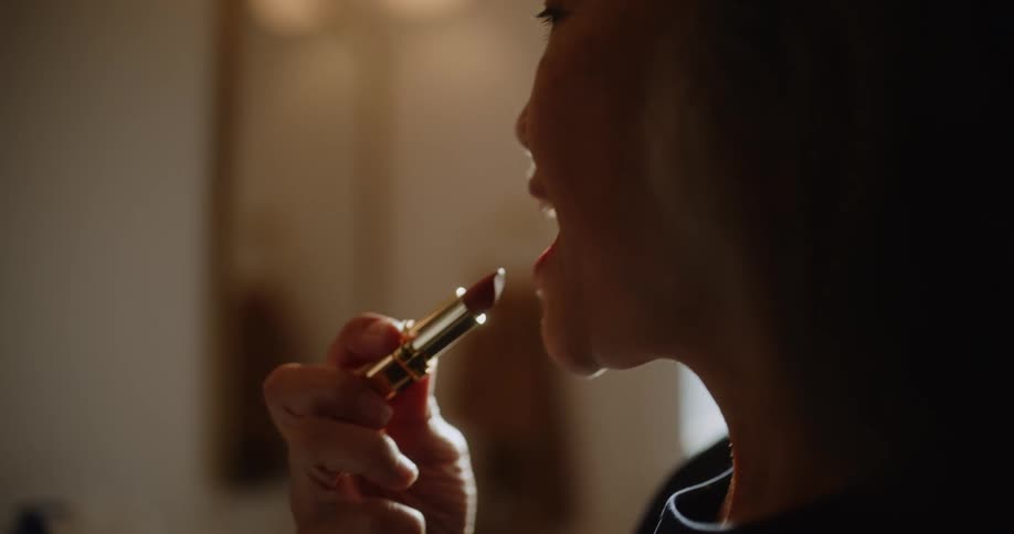 A woman puts on lipstick
