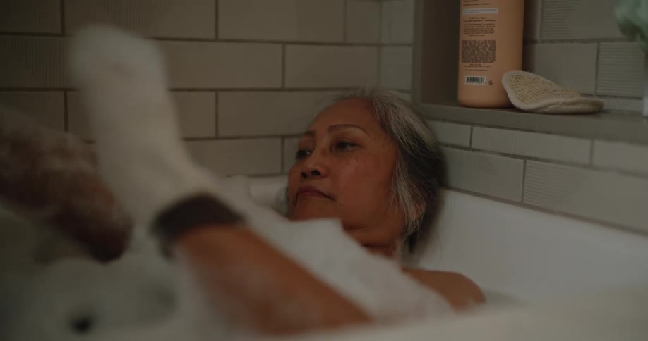 A woman is bathing in the tub
