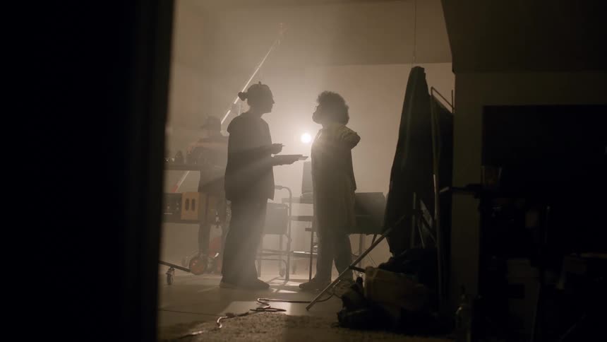 Two women talking inside a studio with lighting and equipment