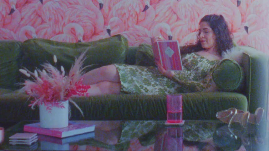 Young woman lying on the sofa reading a book