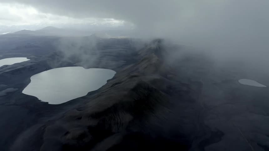 Fog moves over the top of a mountain range