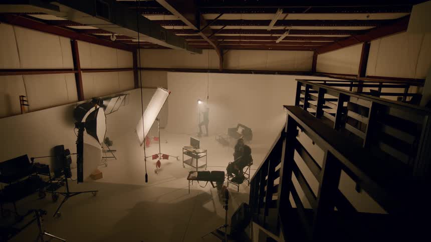 Some people inside a studio with lighting and equipment
