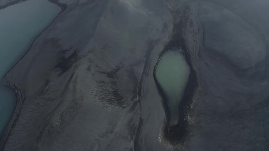 Aerial panorama of craters and black rocks with lakes
