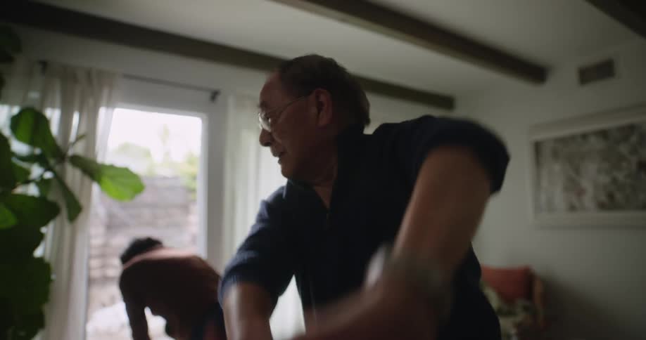 Elderly asian couple exercising in thier living room at home