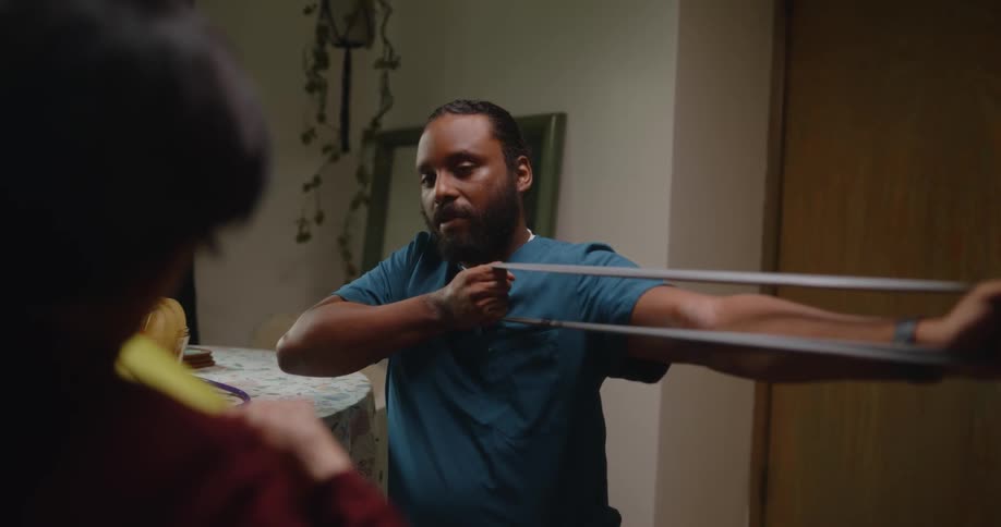 A healthcare worker teaches an old woman how to use bands to stretch