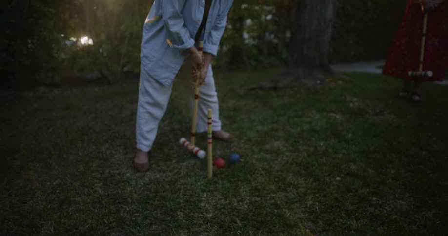 Three elderly women play croquet