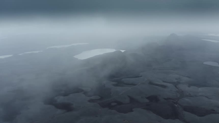 Fog is moving quickly through the rocky landscape