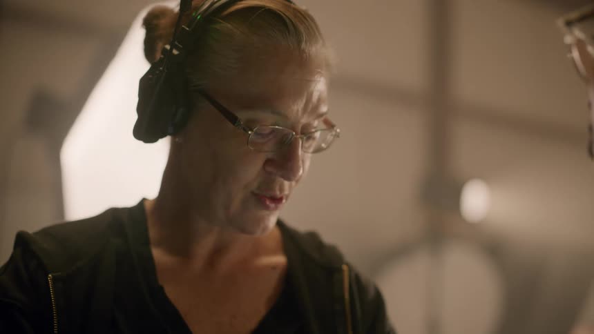Portrait of a woman using a headset talking to a colleague in front of her in an indoor environment
