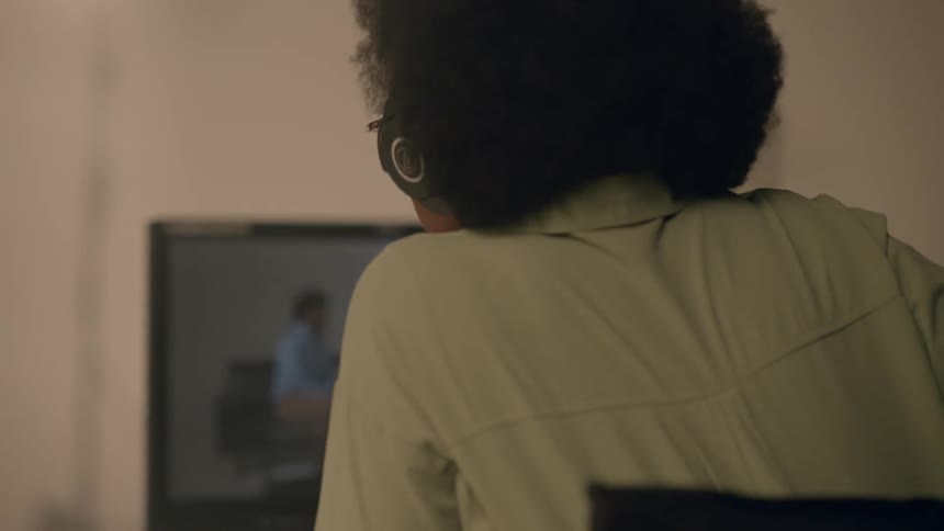 A woman is sitting at her desk in front of a computer