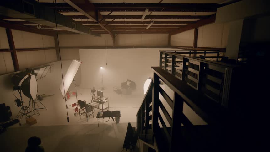 Woman walks away from photography equipmentsetup in photography studio