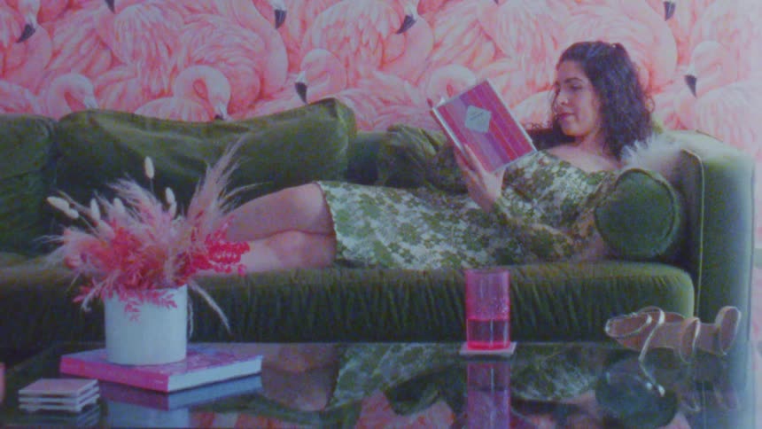 A footage of a lady laying on the couch and reading