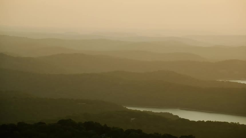 Aerial view of hills and mountains with forests and rivers on a morning with sunlight