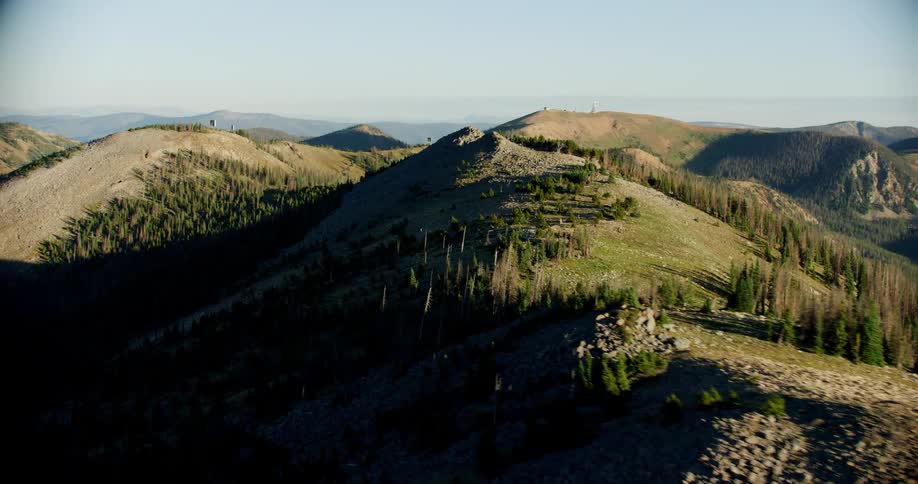 Mountain ranges with coniferous forests on a cloudless blue sky morning