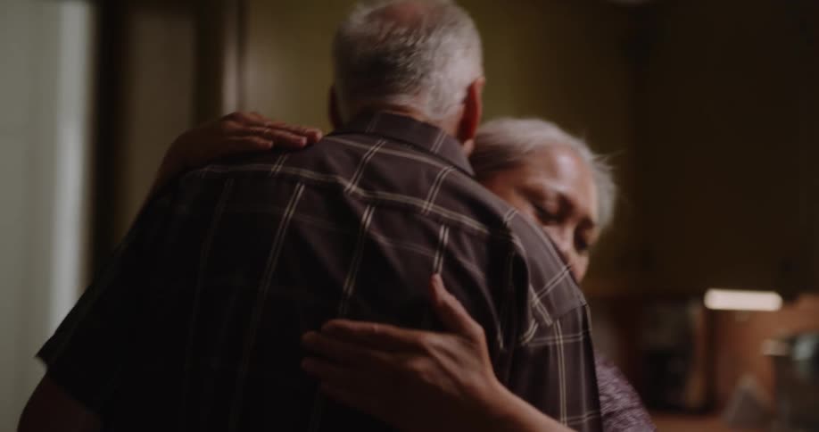 Happy elderly couple hugging and dancing in the kitchen