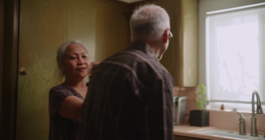 Elderly man and woman are dancing in their home together