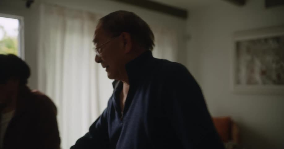 Two elderly asians stretch in a living room