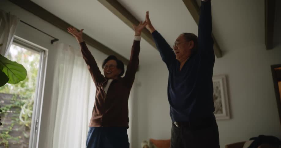 Two asians stretch in a home
