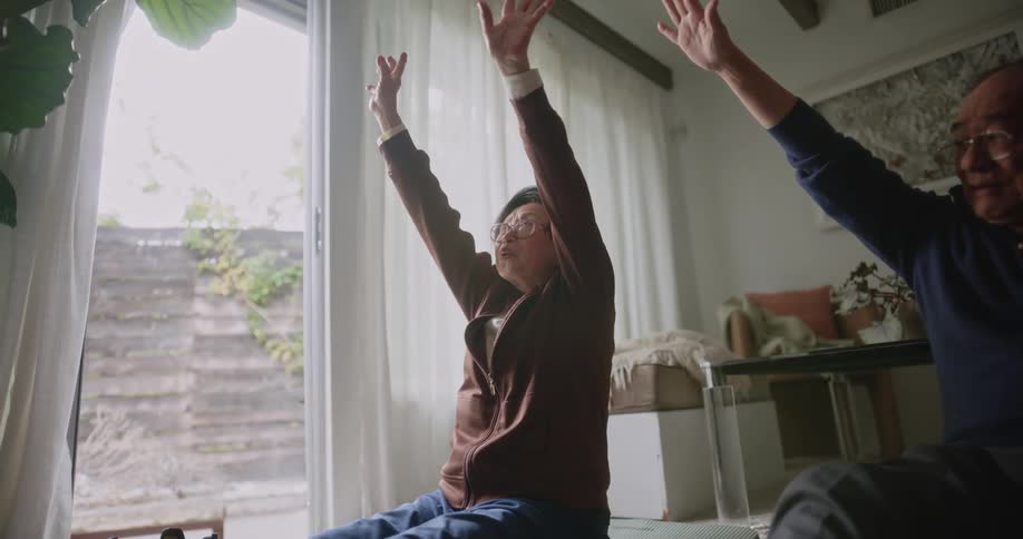 Two asian people laugh and have fun while doing stretches