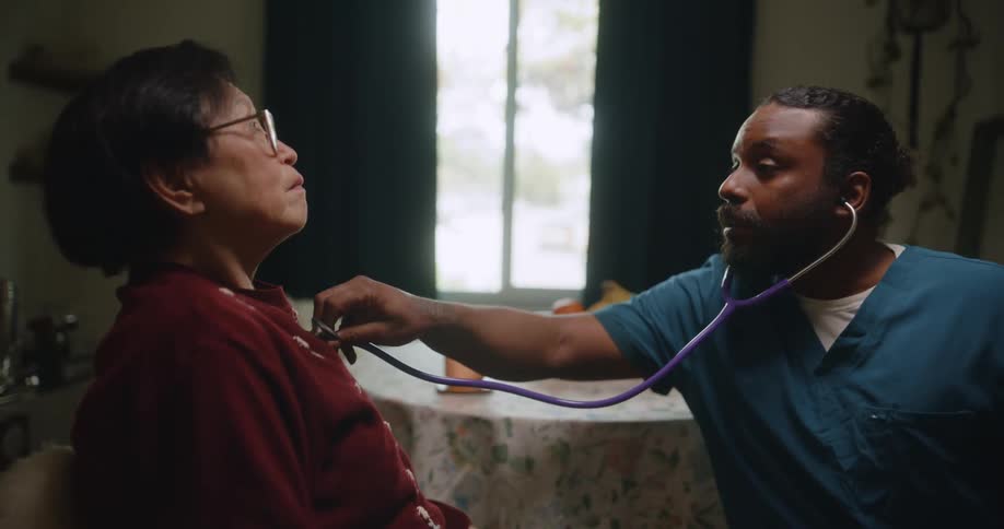 A healthcare worker listens to a patients heart