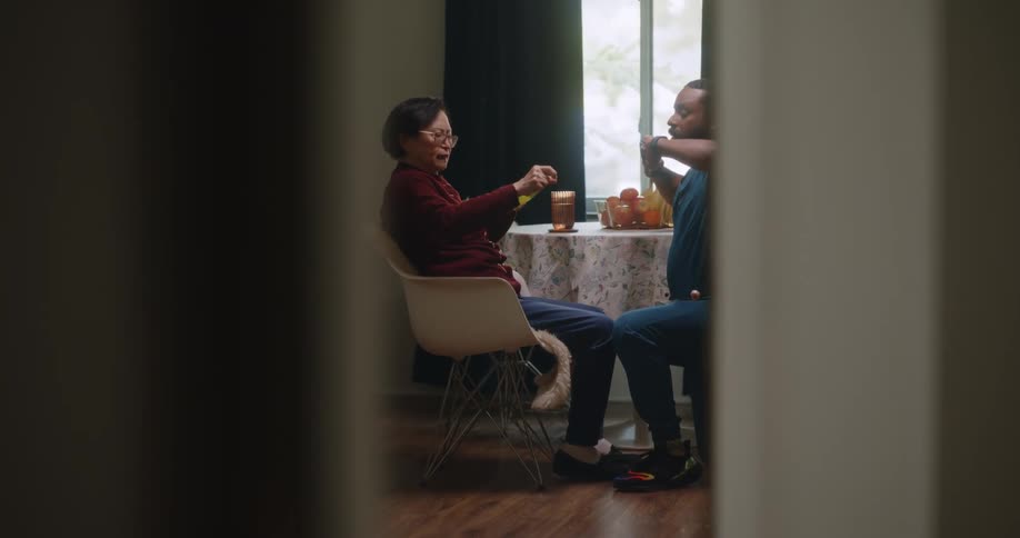 A male nurse helps an elderly asian woman with physical therapy exercises