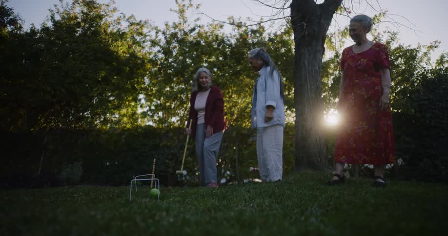 Older female friends playing croquet on the lawn