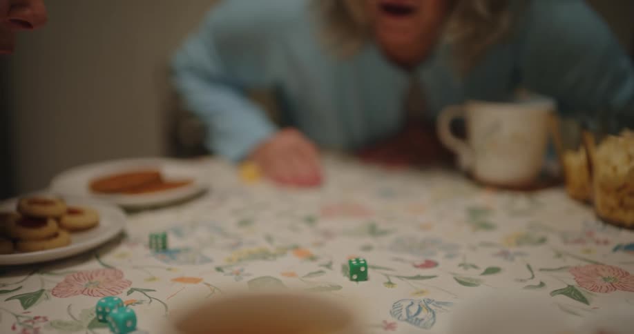 Three women are playing a dice game one woman rolls a pair of dice