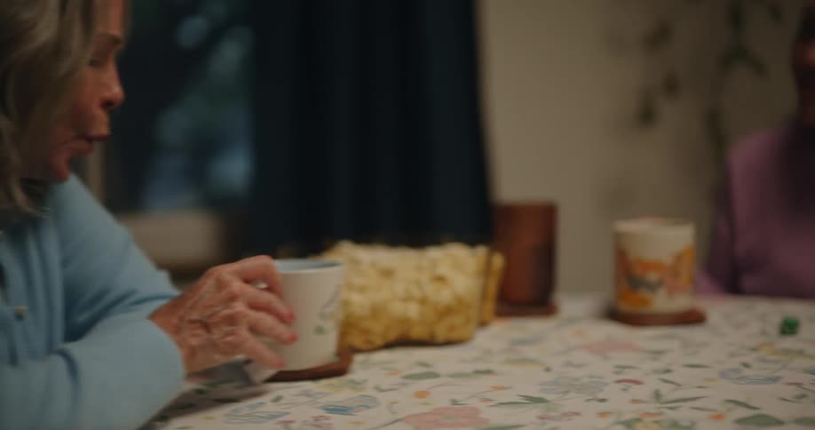 A group of friends drink tea while playing dice games