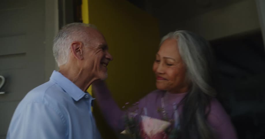 A man gives a woman flowers and enters her home