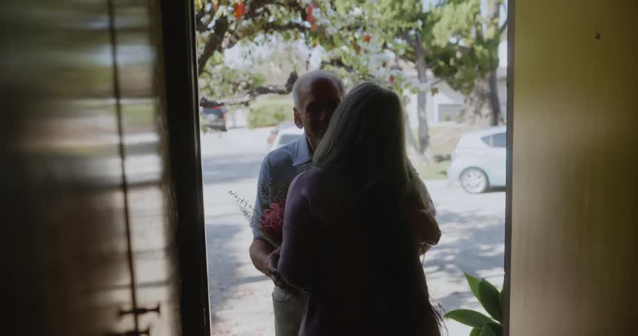 A mature man brings flowers to his partner
