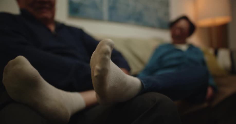 A clip of an old man massaging the feet of his spouse