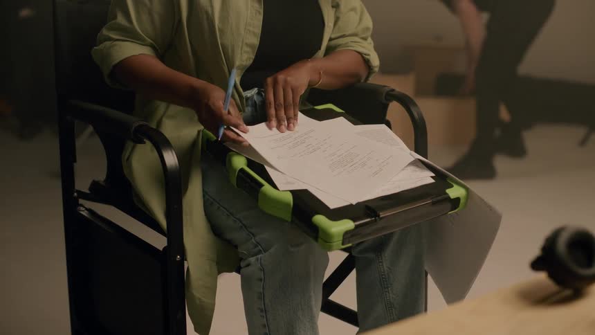 A womans hands writing on a sheet with printed text