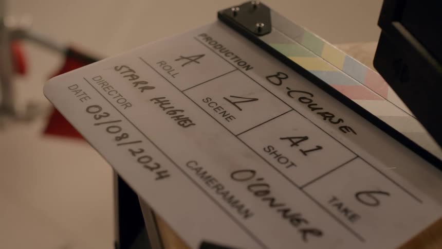 A film clapperboard sits on a desk
