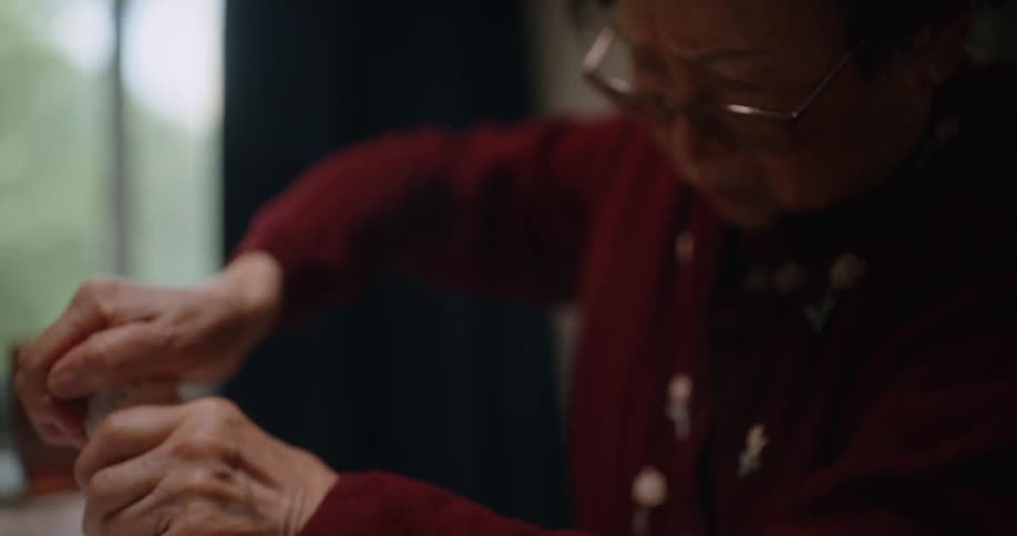 Elderly woman struggling to open a medicine bottle