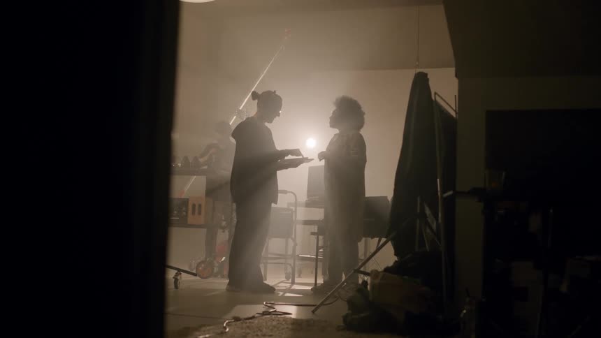 Woman inside a studio talking to a colleague who uses a tablet