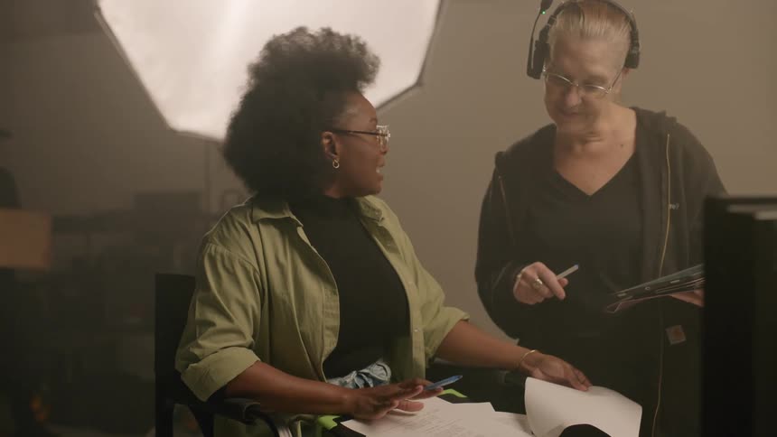 Two women have a discussion on a film set